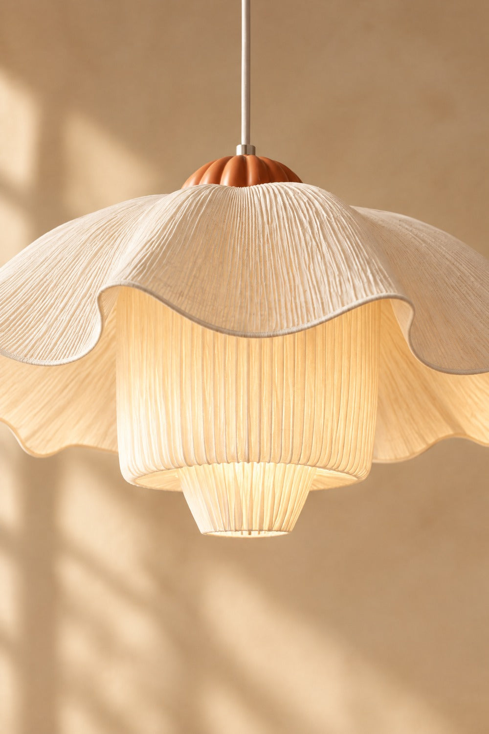 Lumière chaude à travers le tissu plissé de la suspension KALK