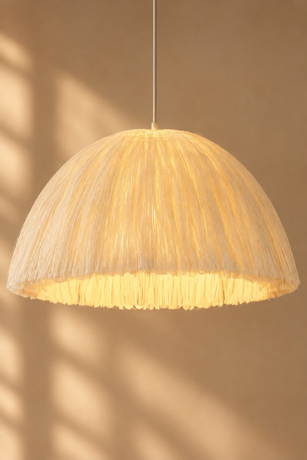 Suspension HAMP allumée, lumière chaude à travers la jute
